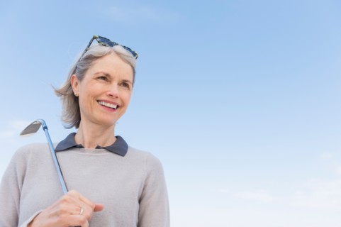 Senior woman holding golf club.
