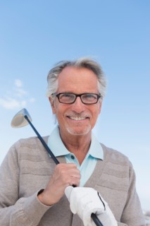 Senior man holding golf club.