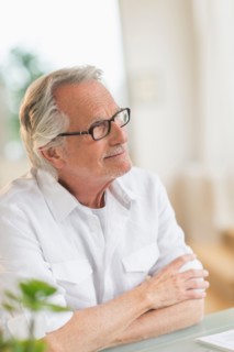 Portrait of senior man sitting at desk.