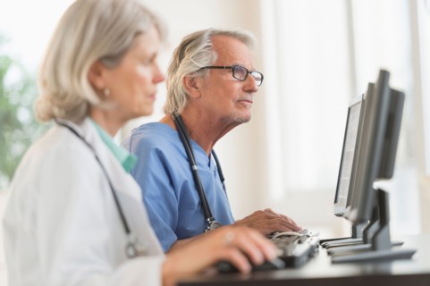 Female and male doctors working at computers.