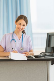 Portrait of female nurse at nurse's station in hospital.