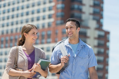 Male and female students walking in campus.