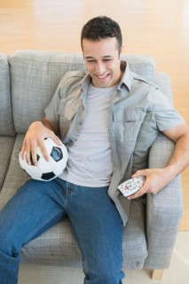 Young man watching soccer match on tv.
