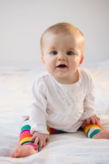Portrait of baby girl (6-11 months) sitting in bed