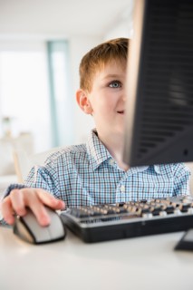 Portrait of boy (4-5) using desktop PC