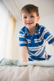 Portrait of boy (4-5) on bed