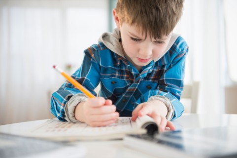 Portrait of boy (4-5) writing with pencil