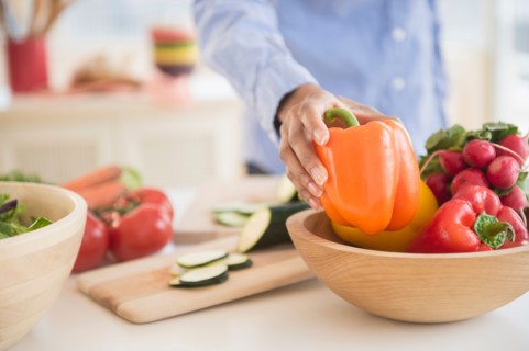 Mid section of woman holding pepper