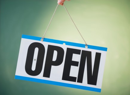 Studio Shot of human hand holding open sign