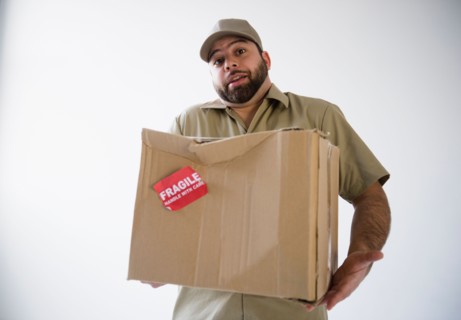 Delivery man holding damaged cardboard box