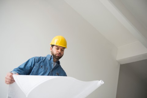 Portrait of construction worker looking at blueprints