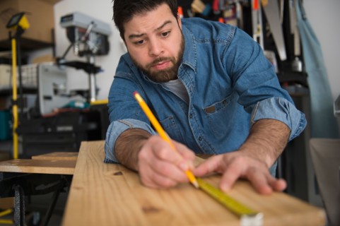 Portrait of man doing marks on wooden board
