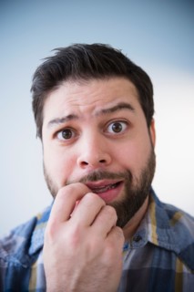 Portrait of nervous man biting nail