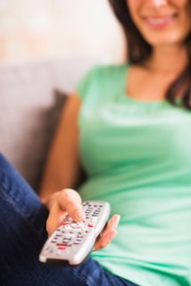 Close up of woman's hand holding remote control