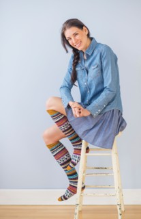 Studio Shot of woman sitting on stool wearing striped kneesocks