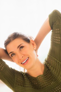 Woman with hands behind head
