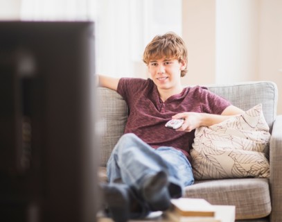 Teenage boy (14-15) watching tv