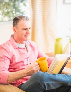 Man sitting on sofa and reading book