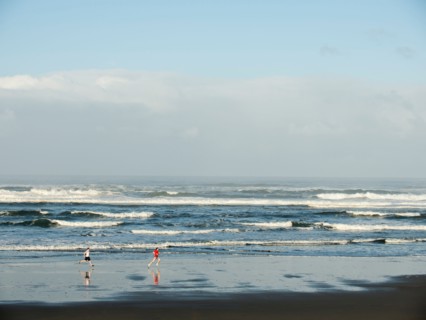 Young adult men running on beach