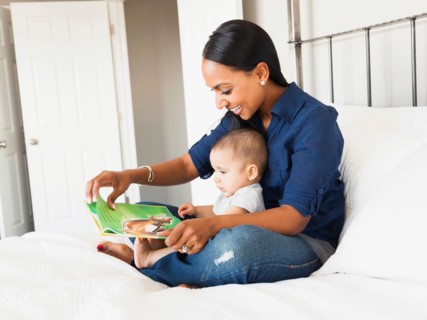 Mother showing her son (2-5 months) book and reading