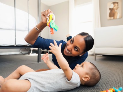 Mother playing with her son (2-5 months) on the floor of living room