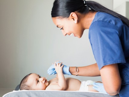 Nurse playing with ill baby boy (2-5 months)