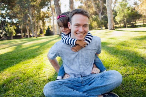 Daughter (4-5 years) embracing her father in park