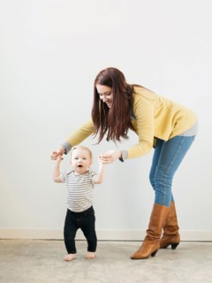 Baby girl (12-17 months) walking while mother assisting her