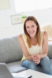 Portrait of young woman sitting on sofa.