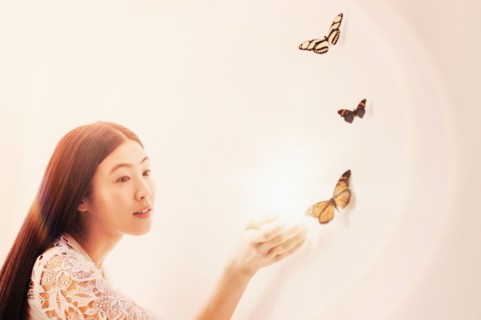 Studio shot of woman looking at butterflies.