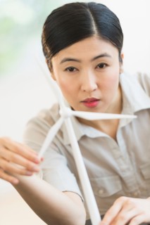 Female engineer working on model of wind turbine.