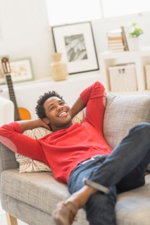 Man lying on sofa and smiling.