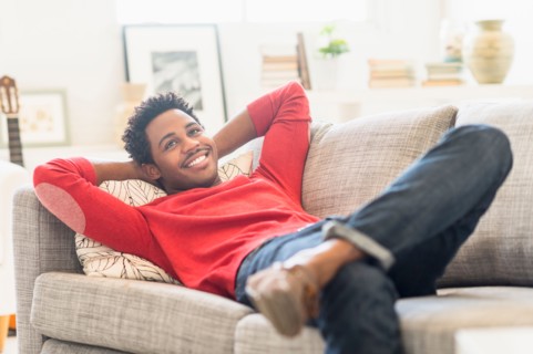 Man lying on sofa and smiling.
