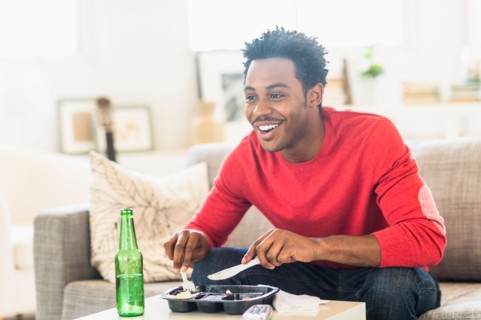 Man eating dinner and watching television.
