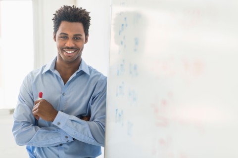 Businessman writing on whiteboard.