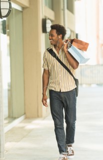 Man walking on street with shopping bags.