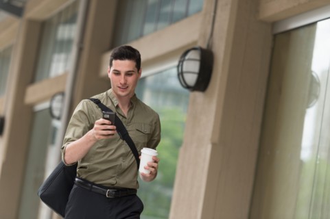 Man walking on street and text messaging.