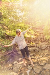 Central Park, New York City. Senior woman crossing stream.