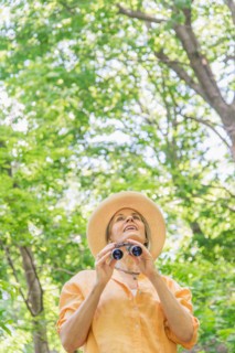 Central Park, New York City. Senior woman with binoculars in park.