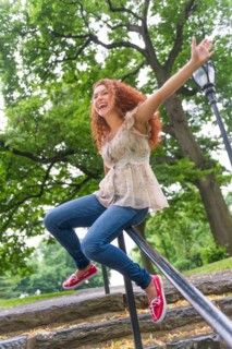 Central Park, New York City. Woman sliding on railing in park.