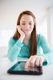 Teenage girl (14-15) using digital tablet