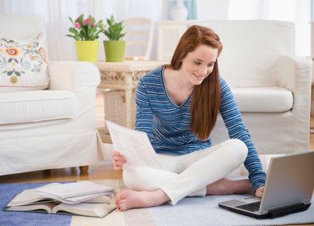 Teenage girl (14-15) studying with laptop