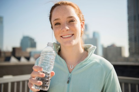 Teenage girl (14-15) with bottle of water