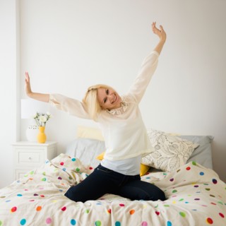 Young woman stretching in bed