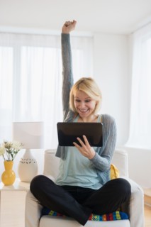 Young woman with digital tablet gesturing in success