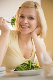Portrait of cheerful woman eating salad