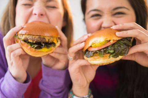 Young women eating hamburgers