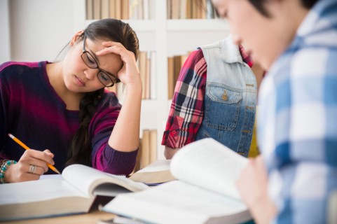 Young women and man studding in library