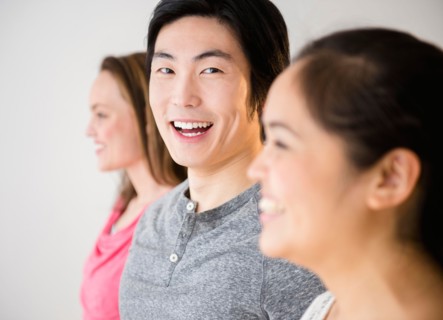 Portrait of young man standing between young women