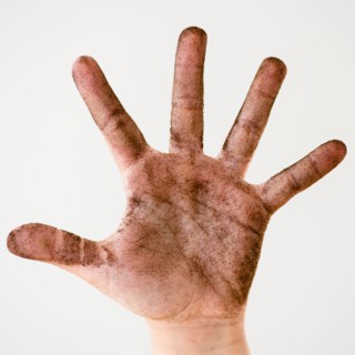 Child hand covered with plant soil